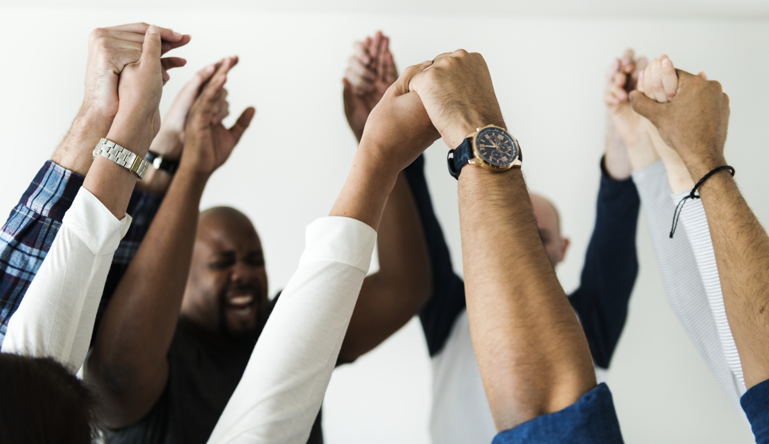 Diverse people joining hands together success and celebration concept